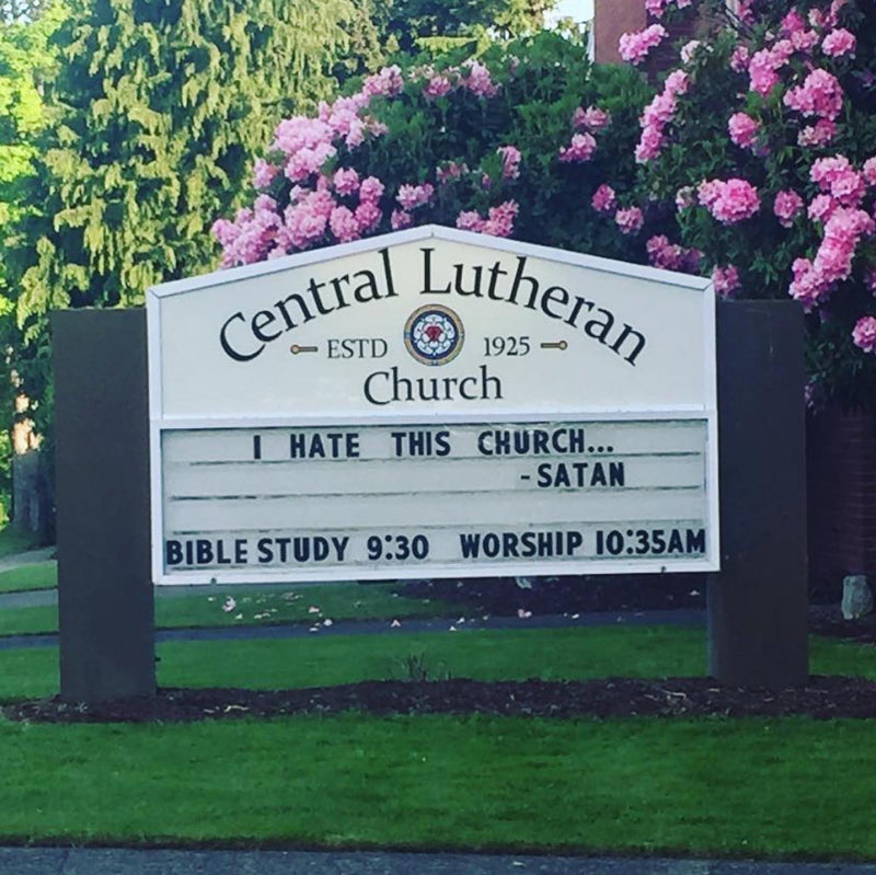 I HATE THIS CHURCH... -SATAN, on a Central Lutheran Church sign surrounded by pink rhododendrons.