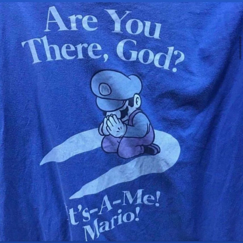 Are You There, God? It's-A-Me! Mario! A blue T-shirt with Mario kneeling in prayer.