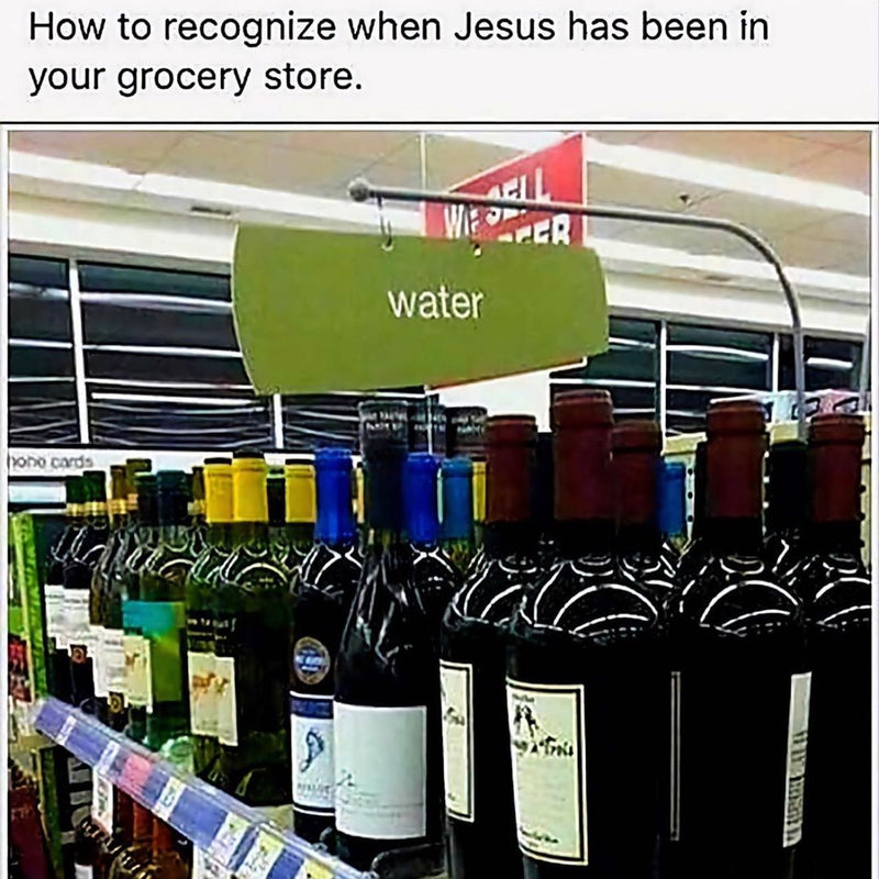 How to recognize when Jesus has been in your grocery store. A store shelf sign reading water hangs over rows of wine bottles.
